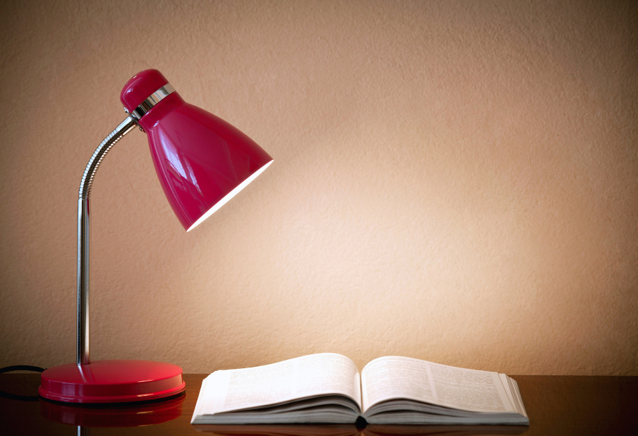 a lamp next to a book on a table